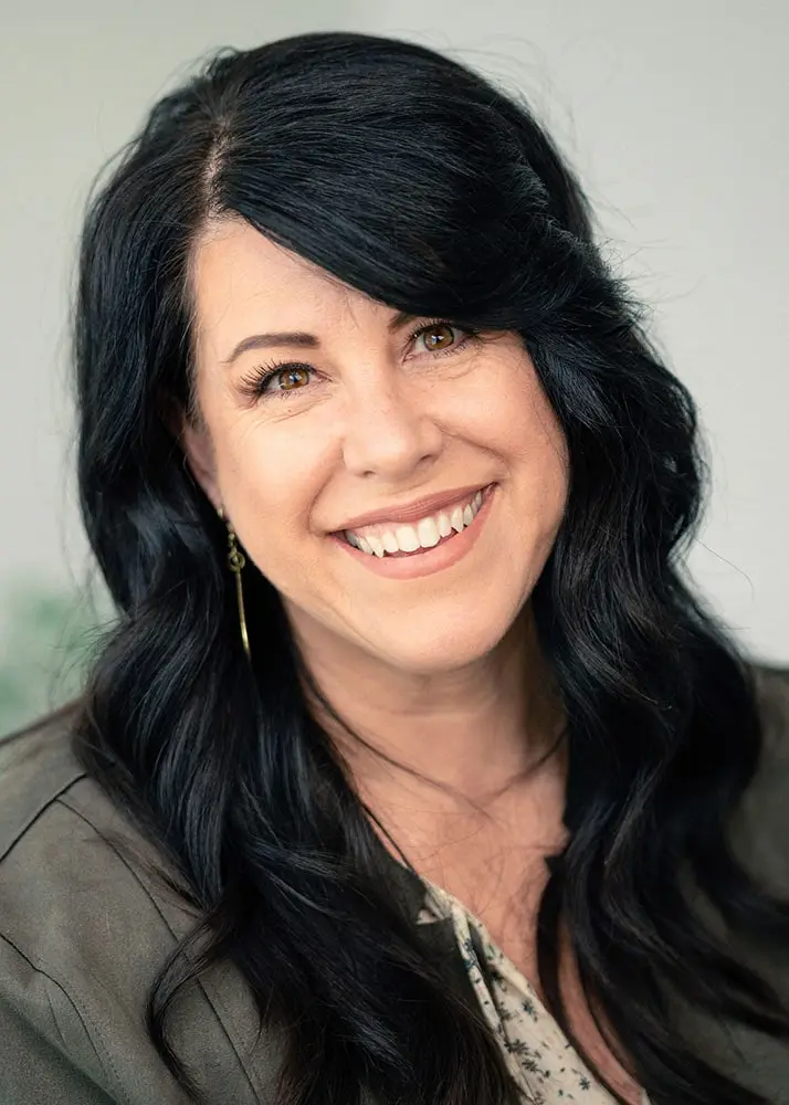 A portrait shot of the owner, Trish. She's brunette, has green eyes, and is wearing a nice leather jacket.