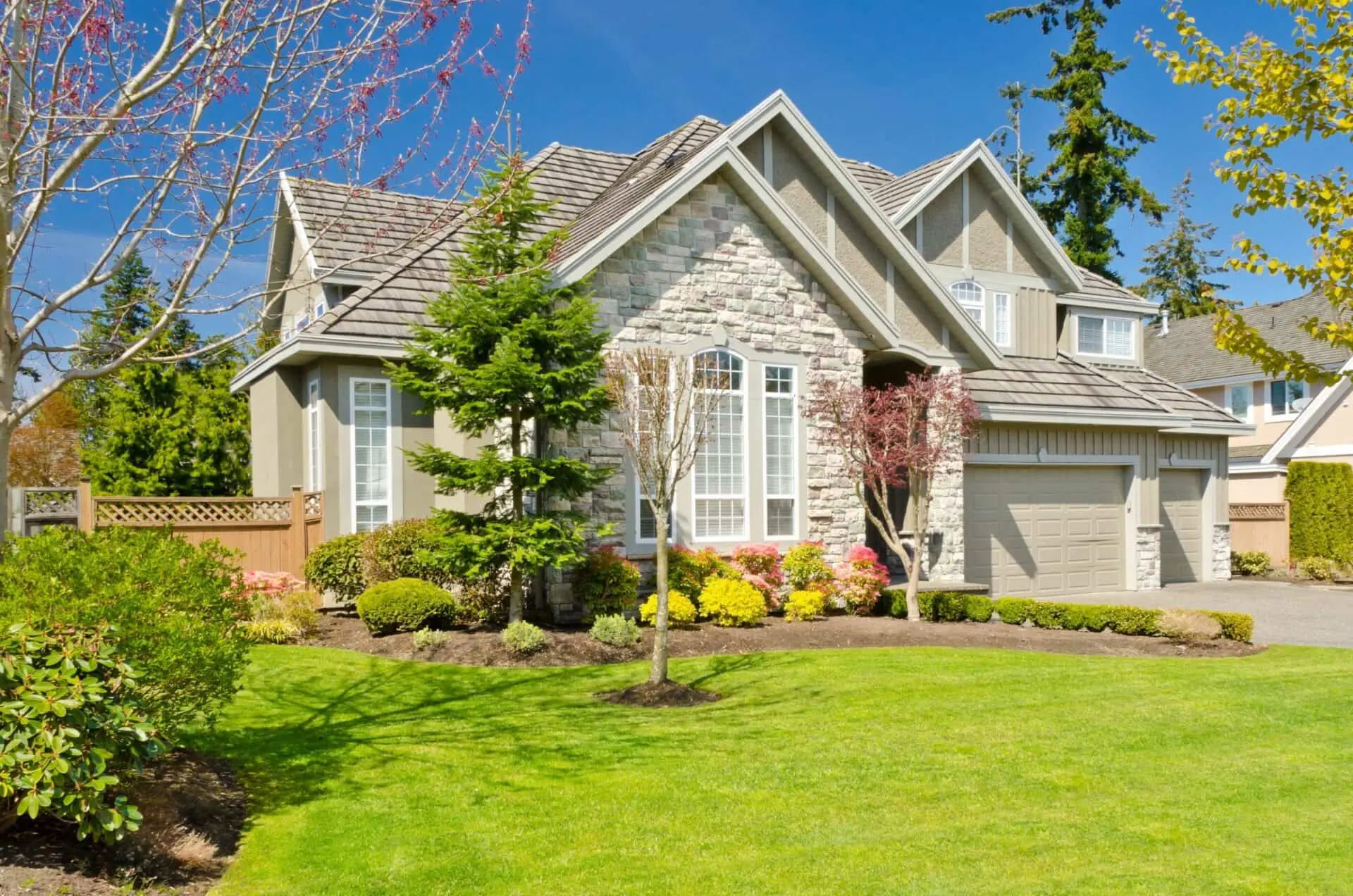 Rich green lawn surrounded with trees and bushes that have benefited from fertilizer injections.