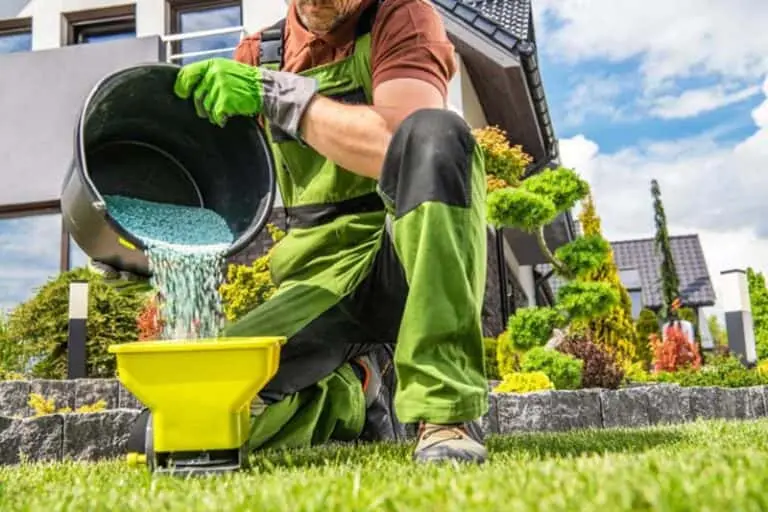 A lawn care technician prepares a custom fertilizer for a client. He is pouring the mix into a yellow container.